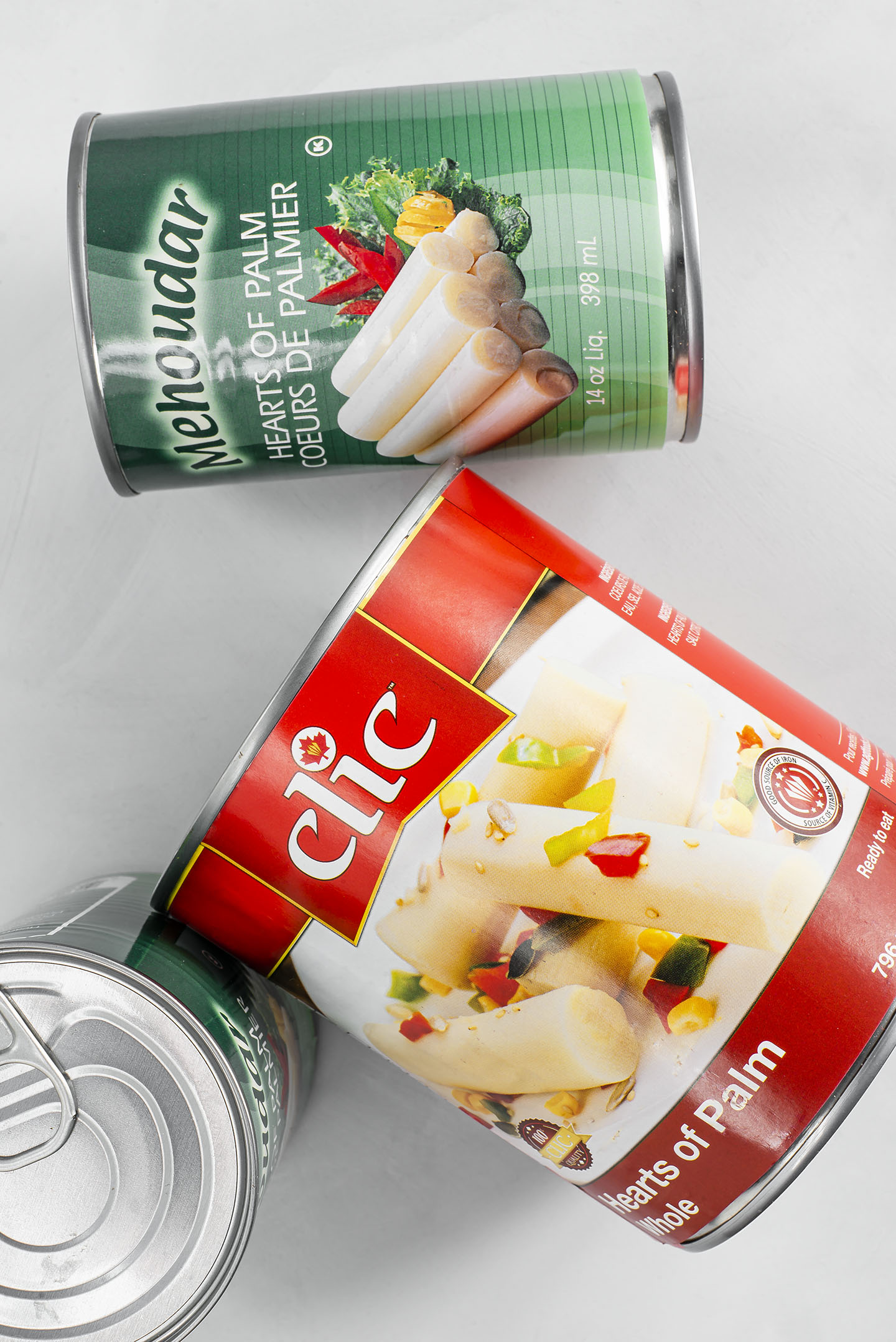 Top down view of various can sizes and brands of hearts of palm. Clic brand 796ml and