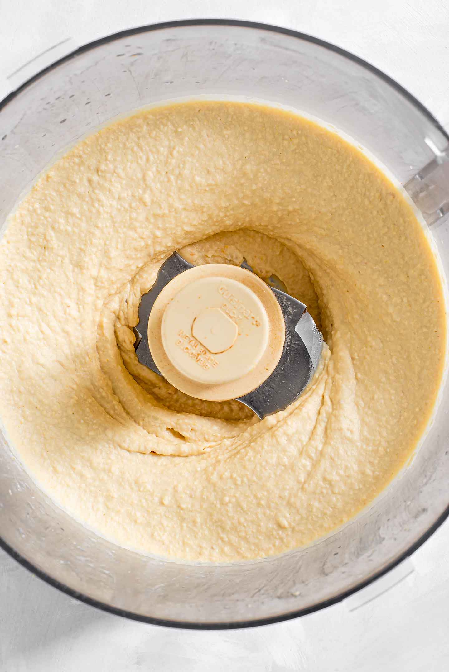 Top down view of easy creamy hummus blended in a food processor