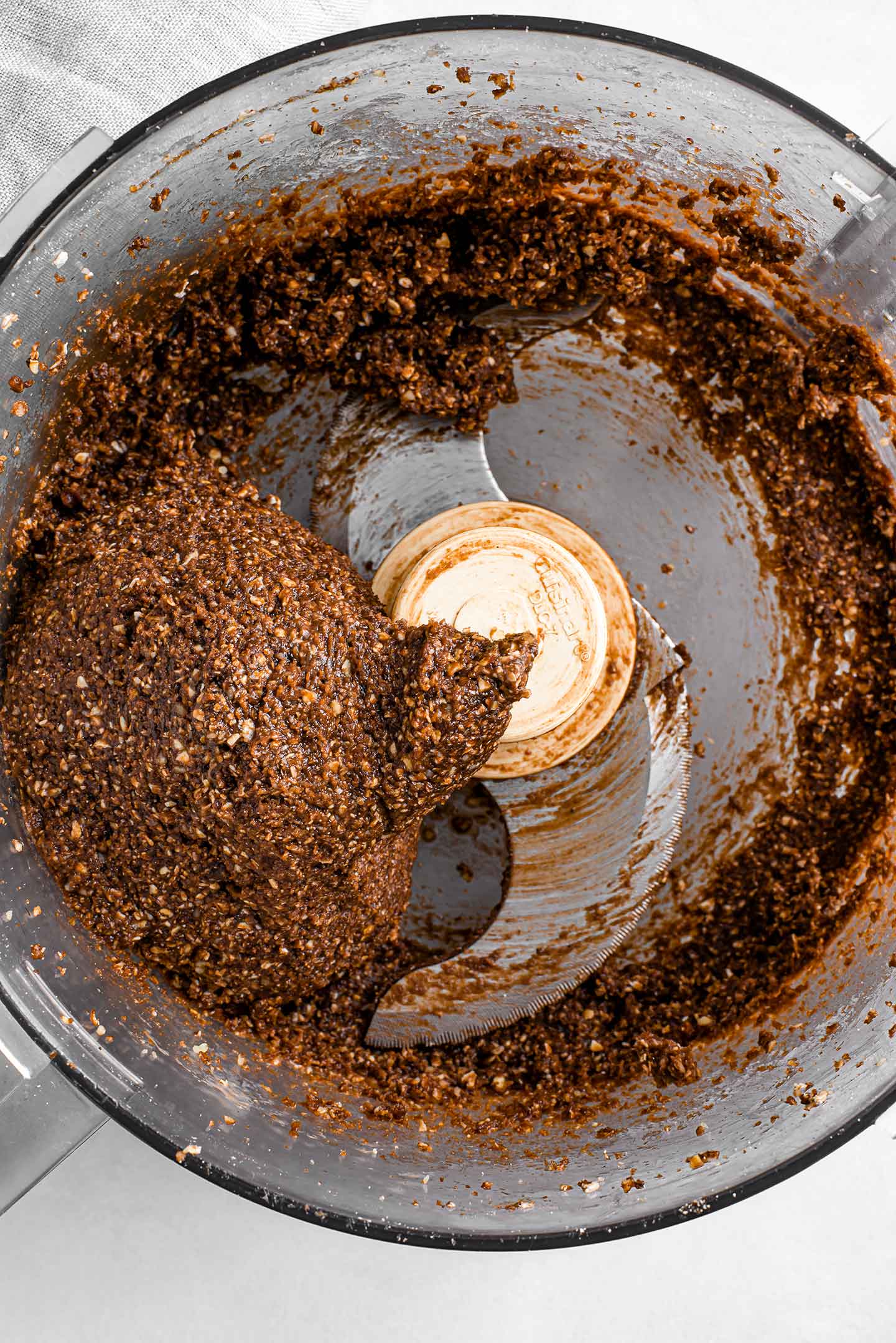 Top down view of brownie energy ball dough in a food processor.