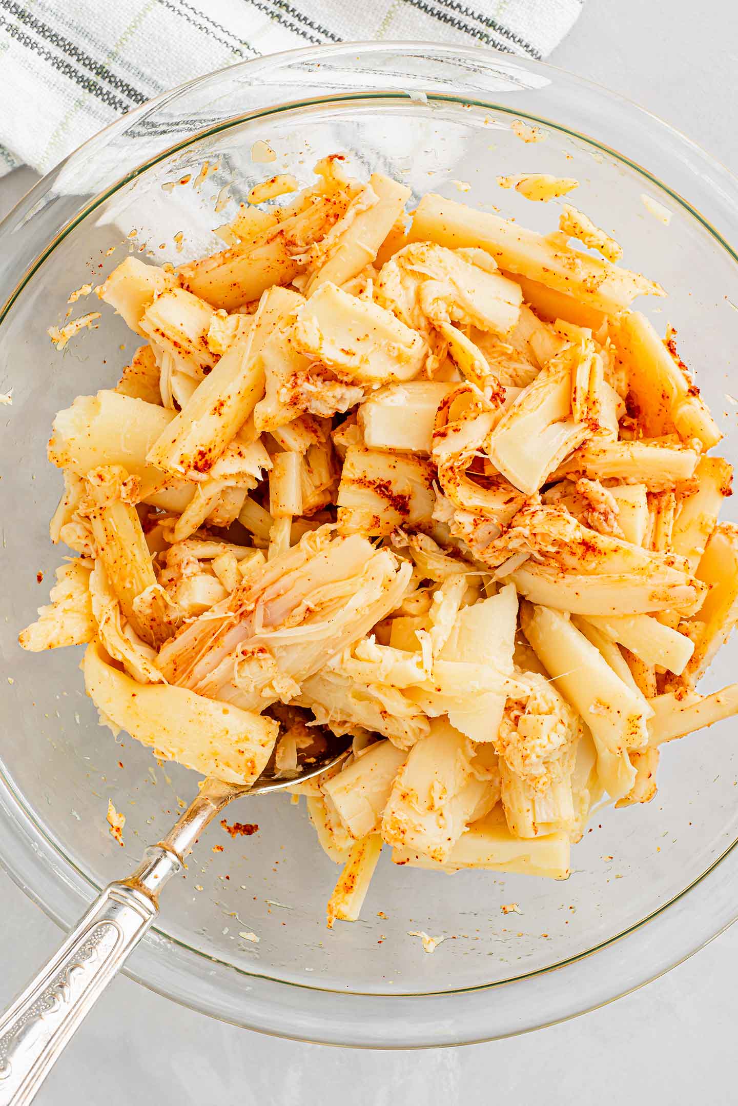 Top down view of torn pieces of hearts of palm resembling pieces of lobster and sprinkled with smoked paprika and garlic powder.