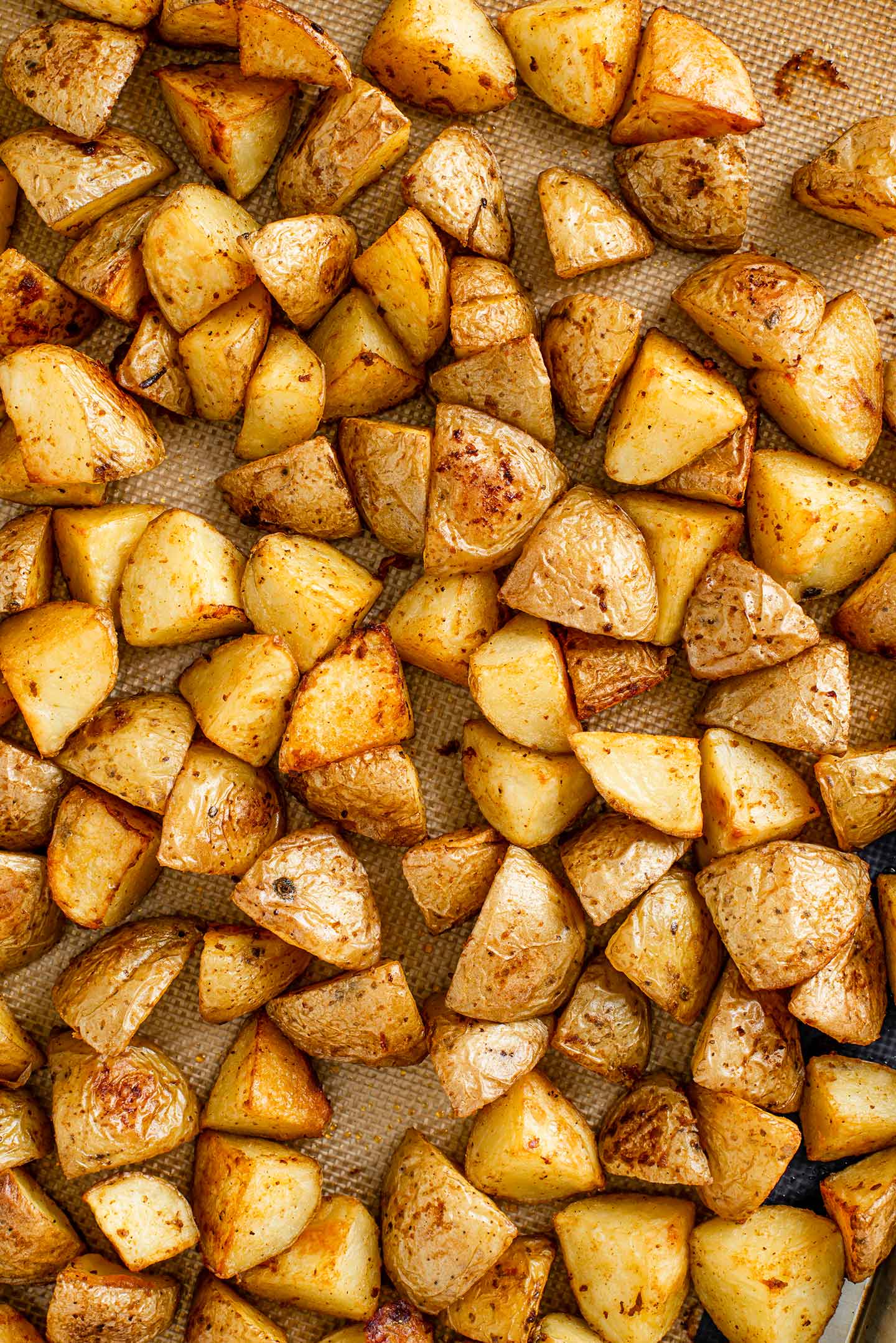 Top down view of crispy simple roasted potatoes in a baking tray.