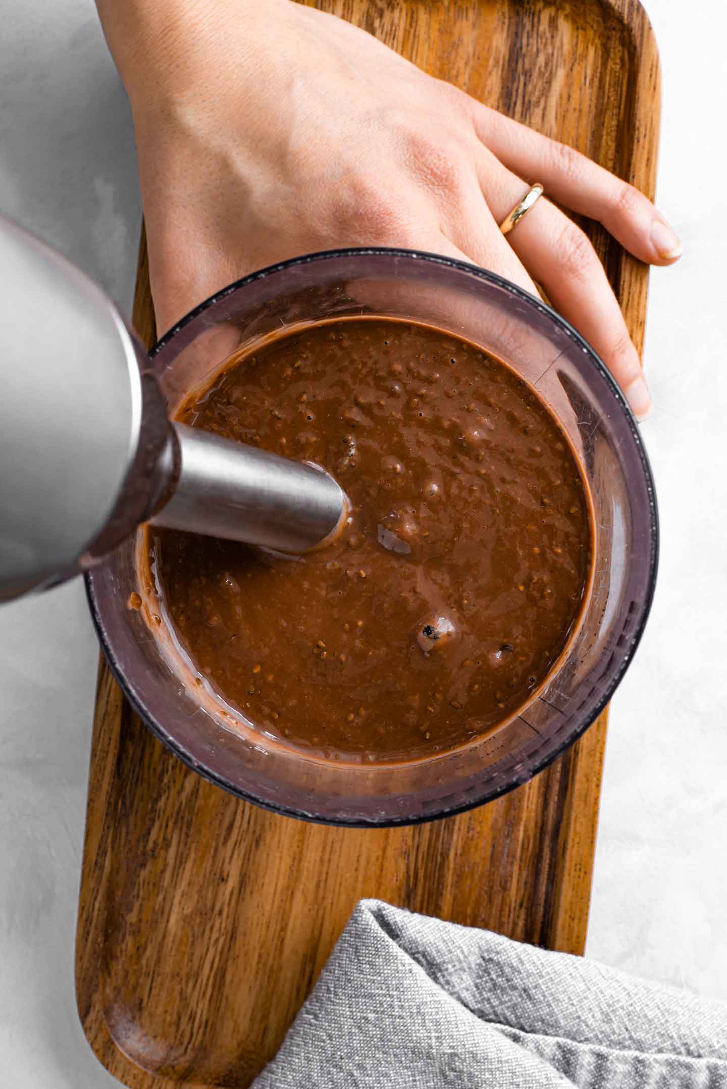 Top down view of quick chocolate pudding being blended using an immersion blender.