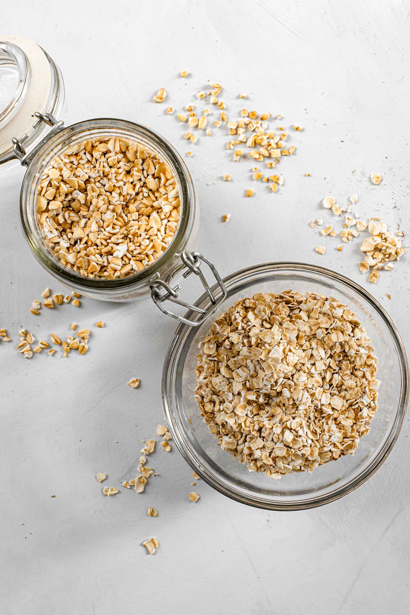 Top down view of steel cut oats in a jar and quick cooking oats in a small glass bowl