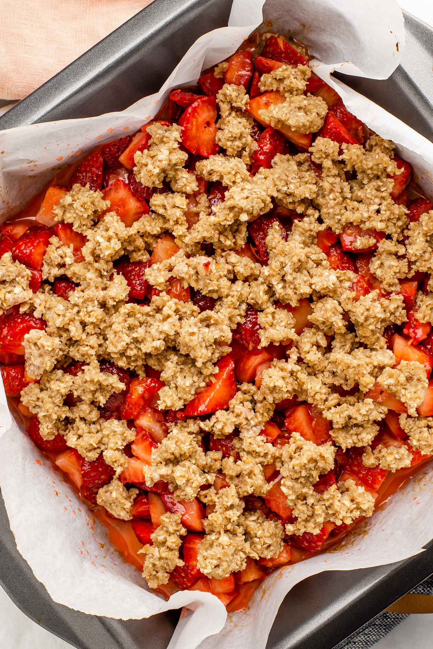 Top down view of the strawberry filling and oat, walnut topping having been added to the pre-baked crust.