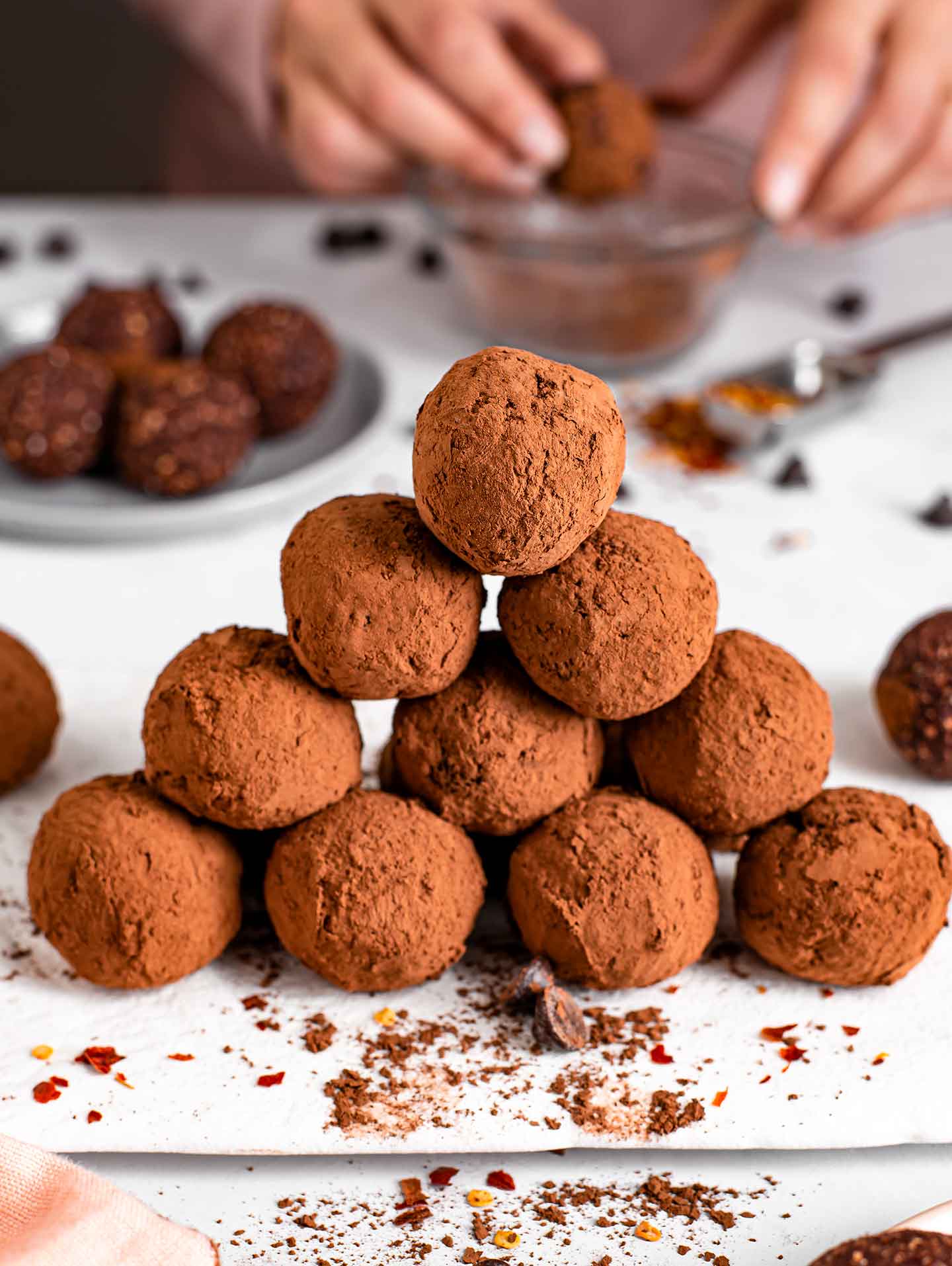 Side view of a delicate triangular stack of spicy dark chocolate chili truffle energy balls.