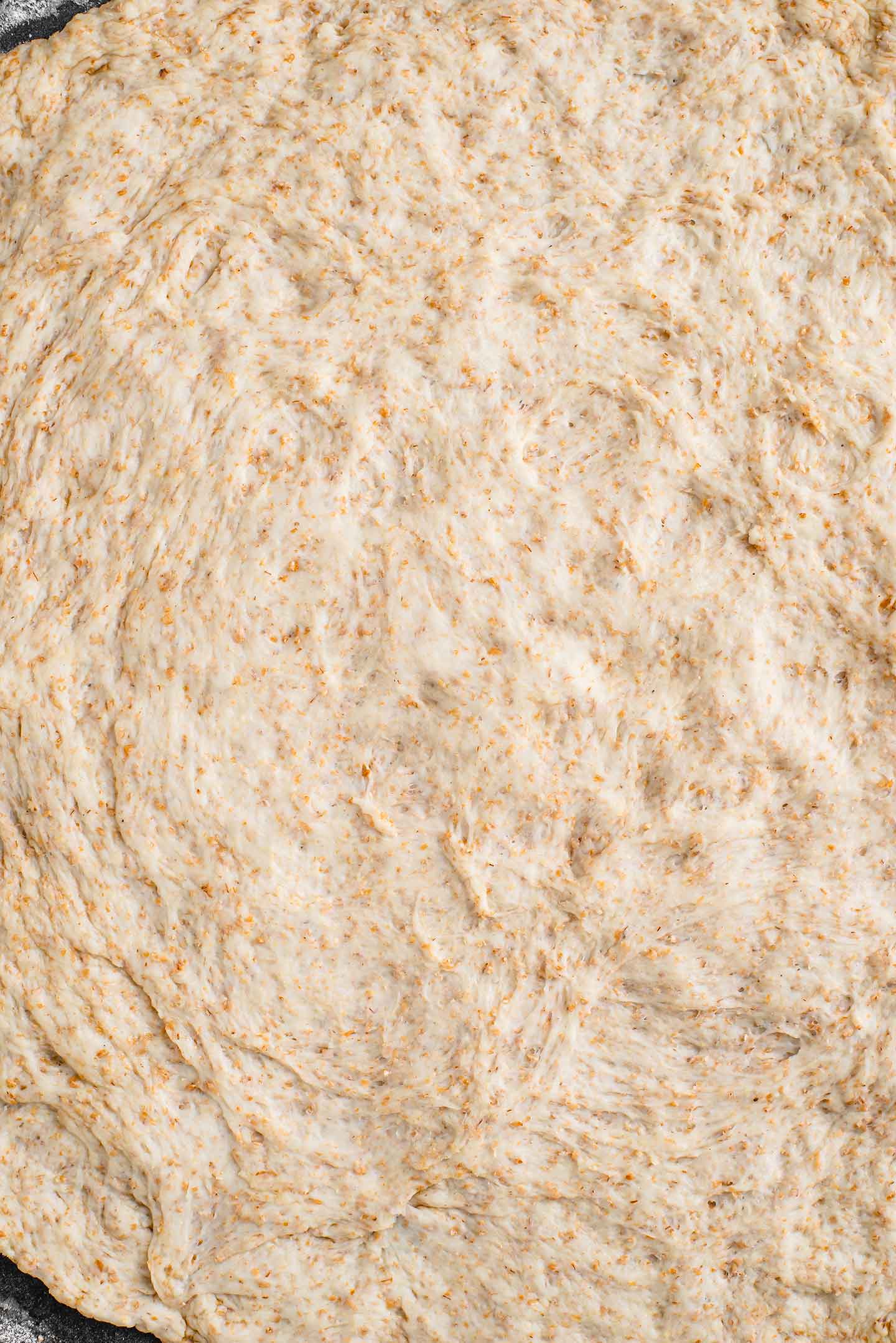 Top down view of pizza dough stretched to fill a pizza pan.