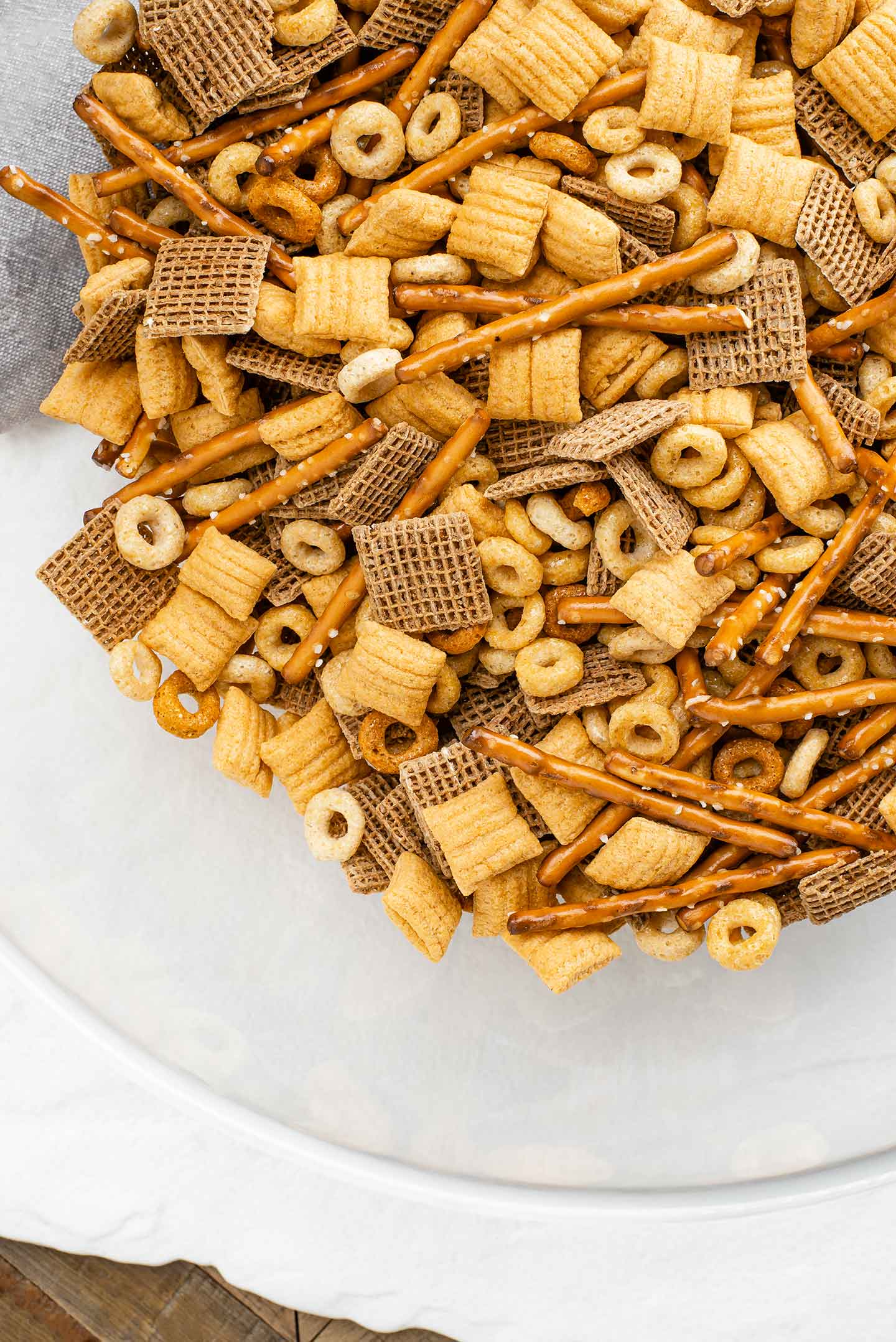 Top down view of party mix in a glass bowl before being tossed in the seasoning mixture.