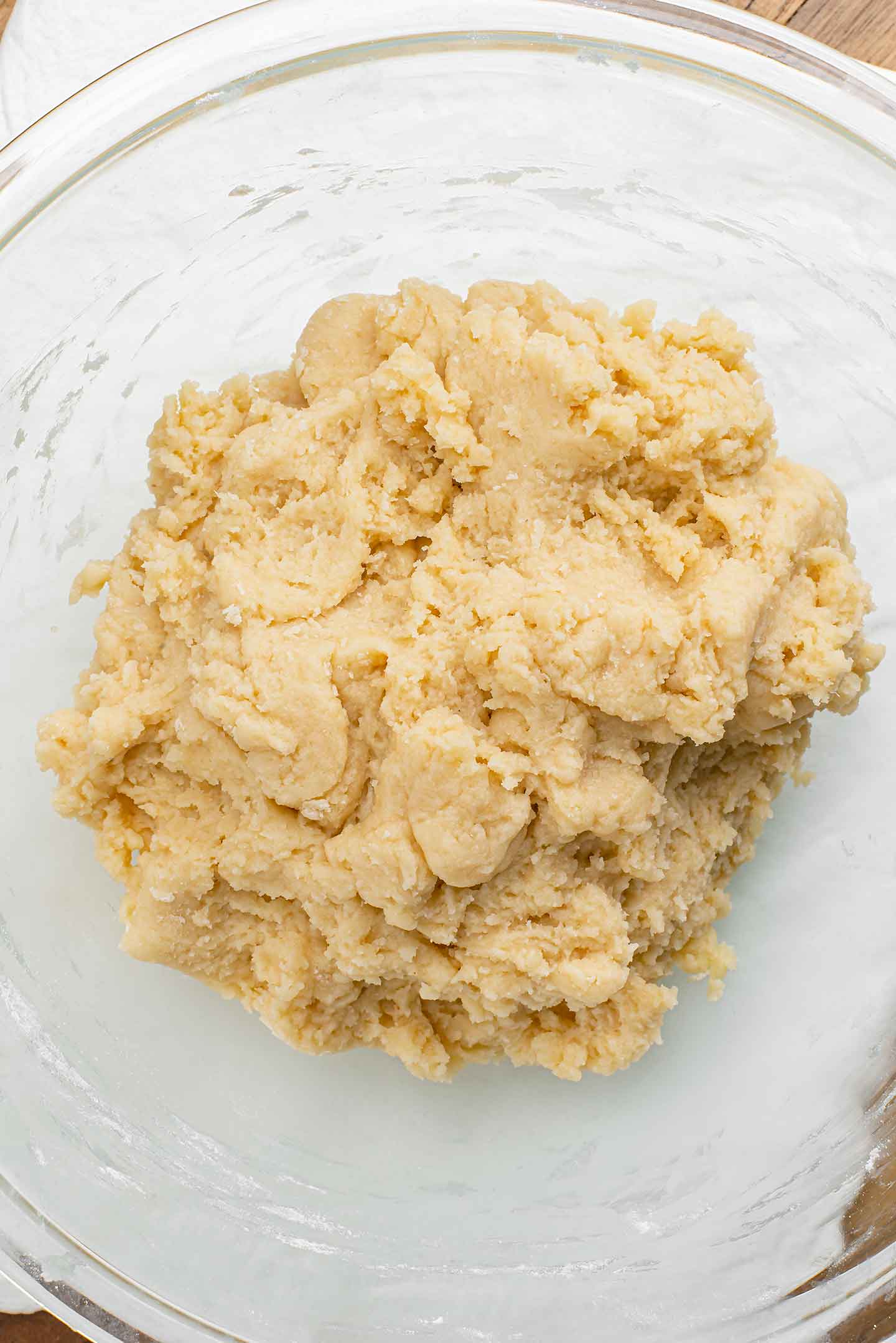 Top down view of a ball of dough in a glass jar. The dough is quite firm and light in colour.