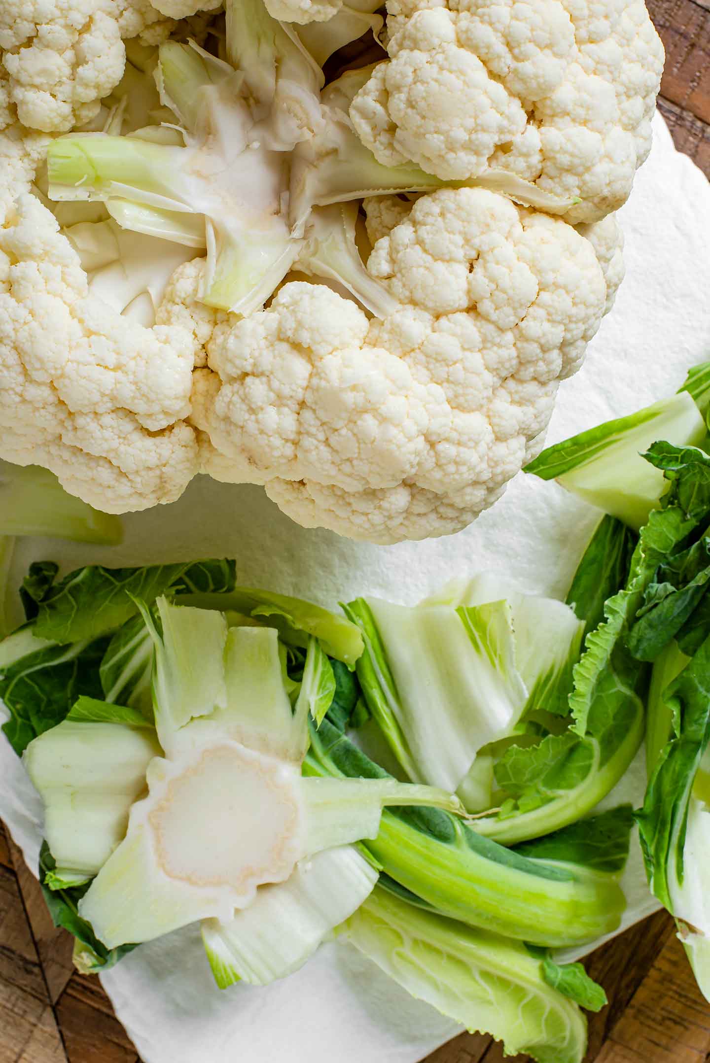 Top down view of a raw cauliflower turned on its head. The leaves and stem have been trimmed.