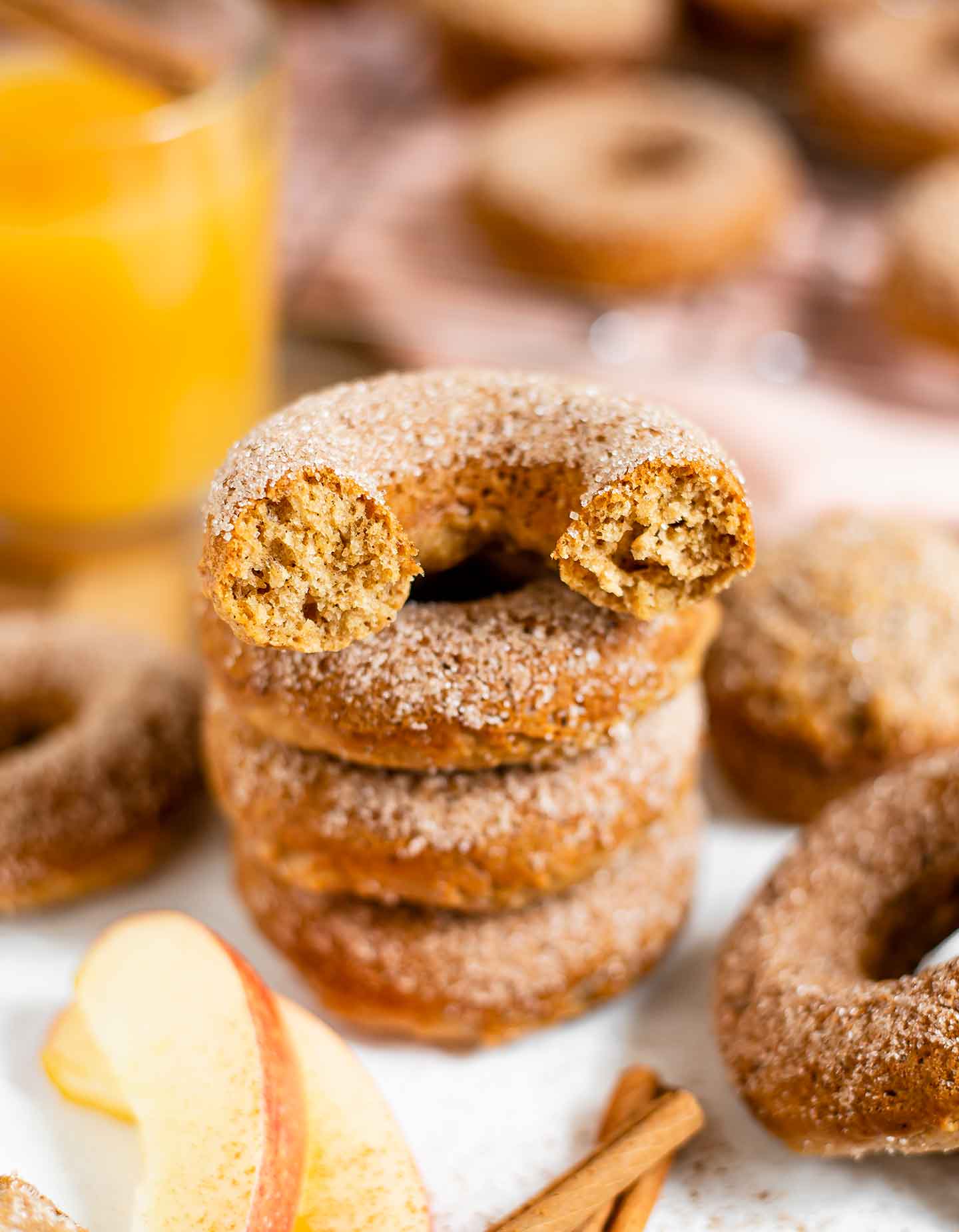 Close up of an apple cider doughnut that has been bitten into. The inside has a fluffy cake-like texture.