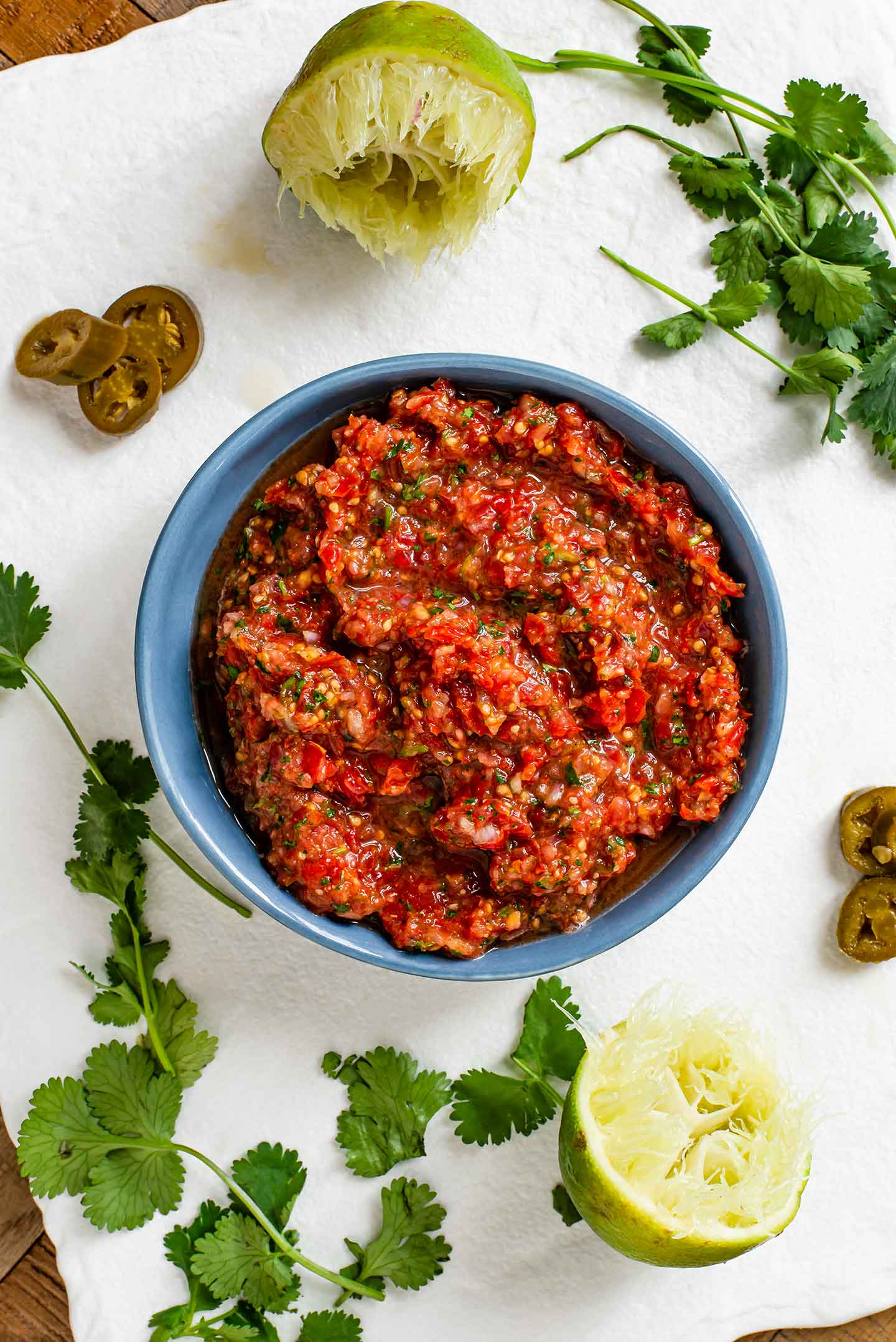 Top down view of easy grape tomato salsa in a small dish. The salsa is speckled with fresh cilantro, onion, and jalapeños. 