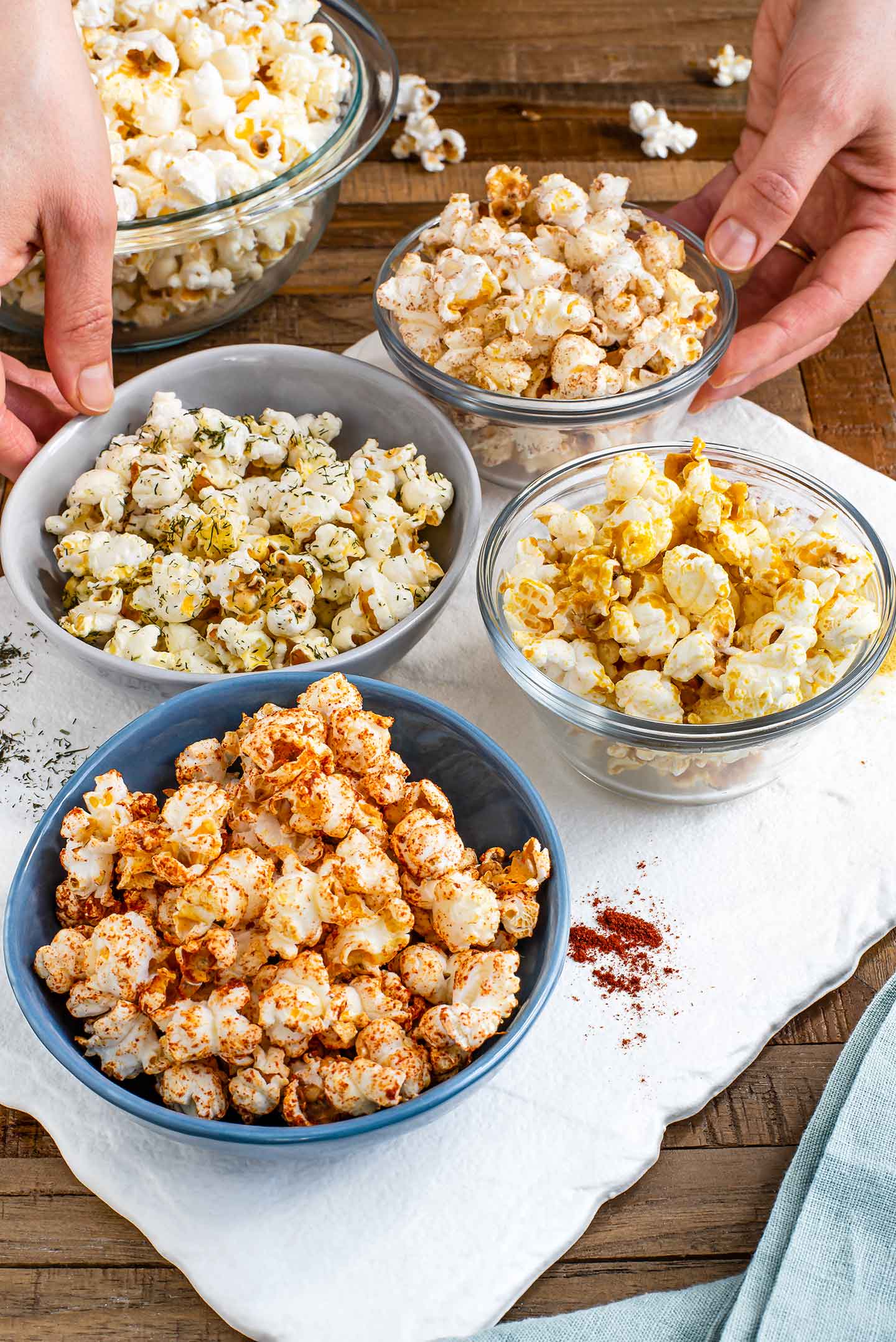 Side view of four small bowls with different flavoured popcorn.