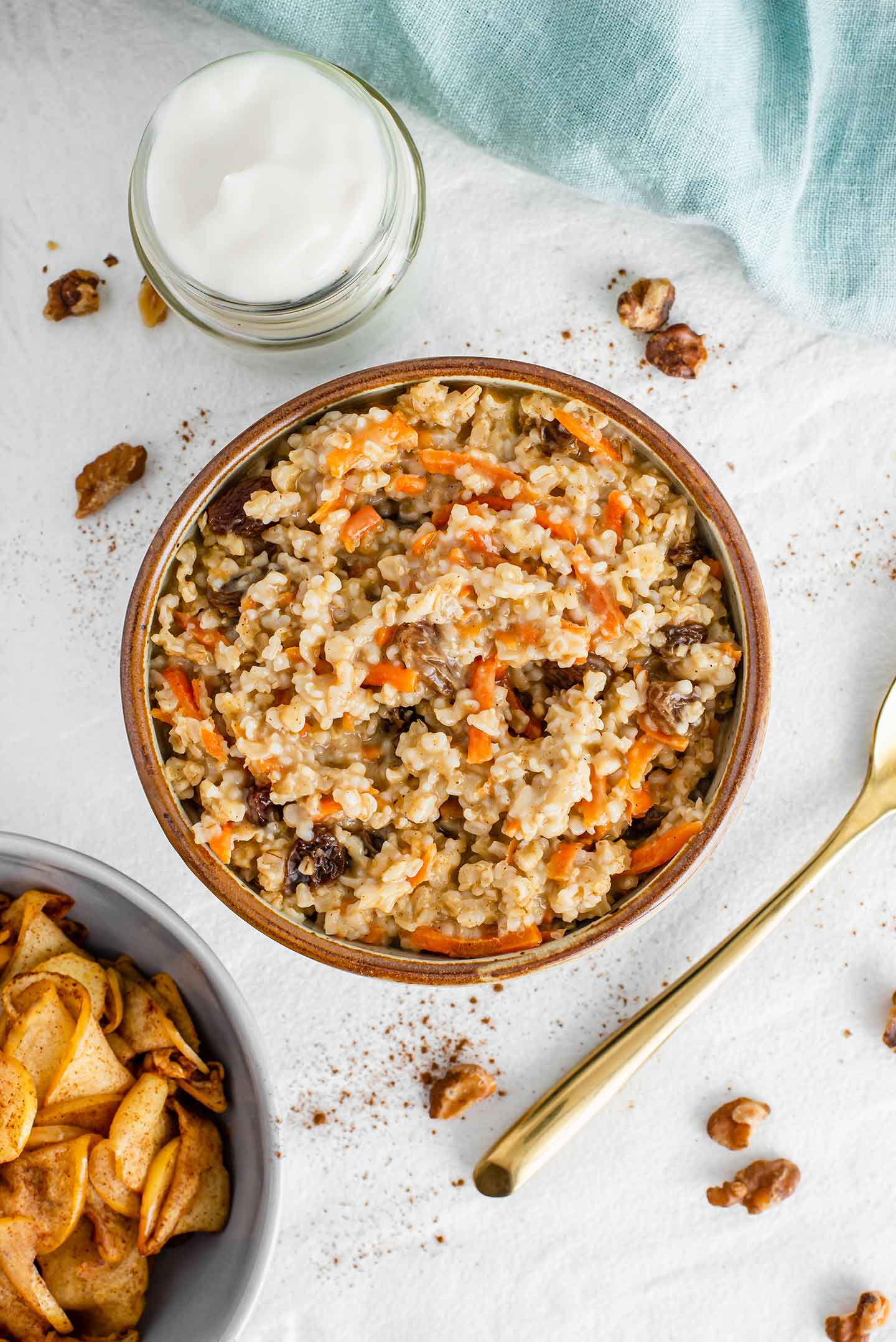 Top down view of a bowl of steel cut oats with shredded carrot and raisins.