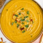 Top down view of a thick and creamy butternut squash red lentil soup in a bowl.