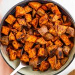 Top down view of crispy cubed sweet potato filling a shallow bowl.