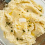 Fluffy vegan mashed potatoes with a dollop of melting butter in the centre.
