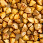 Crispy roasted potatoes fill a baking tray.