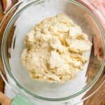 Top down view of tofu ricotta in a glass bowl. The tofu ricotta looks creamy but textured.