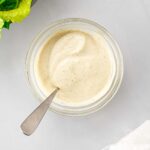 Top down view of creamy vegan caesar dressing in a bowl with a spoon.