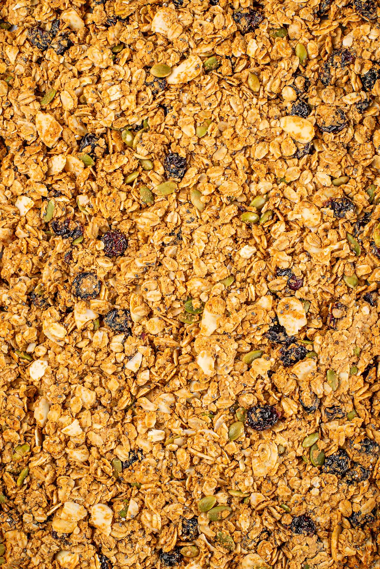 Top down view of golden baked granola in one solid mass on a baking sheet. 
