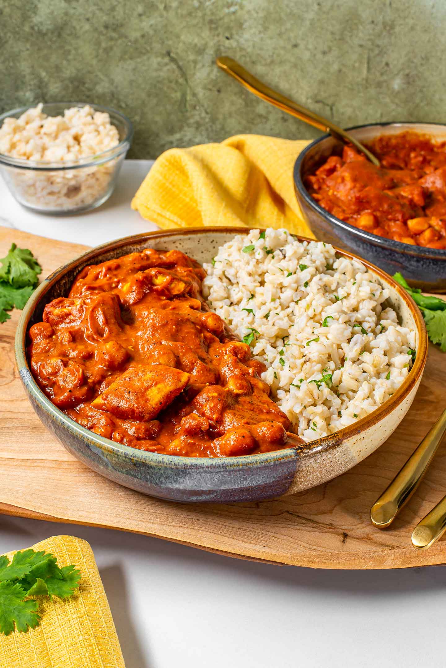 Large chunks of tofu and chickpeas covered in a thick reddish orange gravy make a delicious vegan butter chicken served alongside rice.