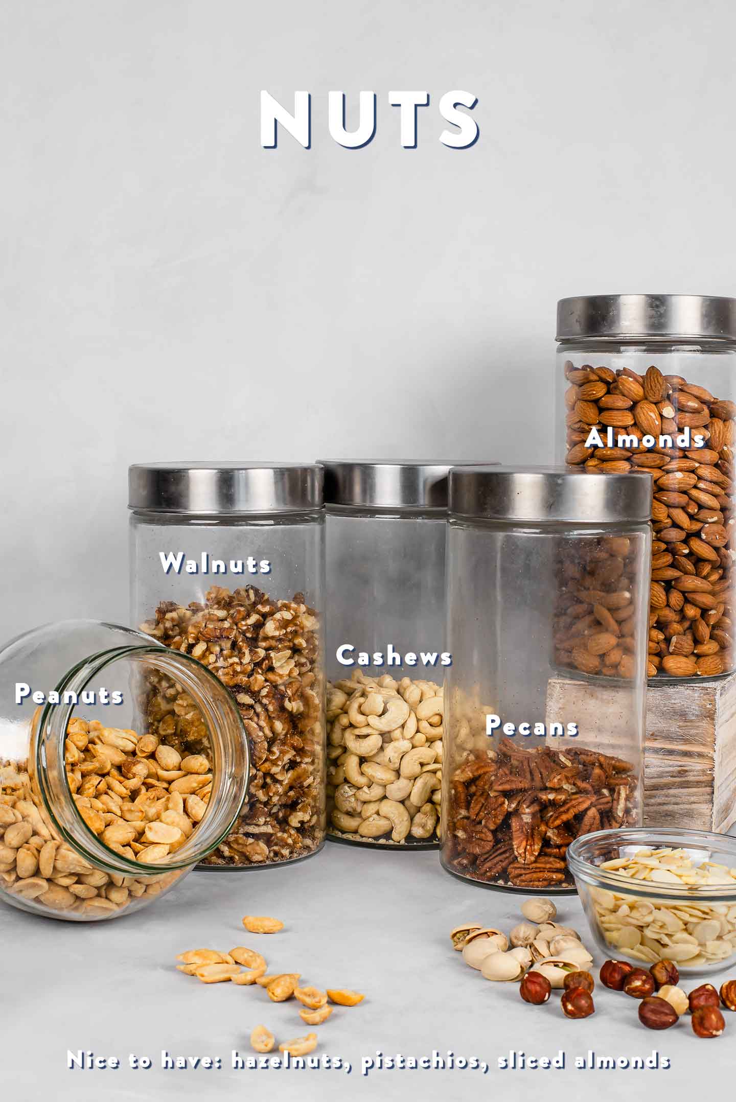 Grouping of an assortment of nuts in various large glass jars.