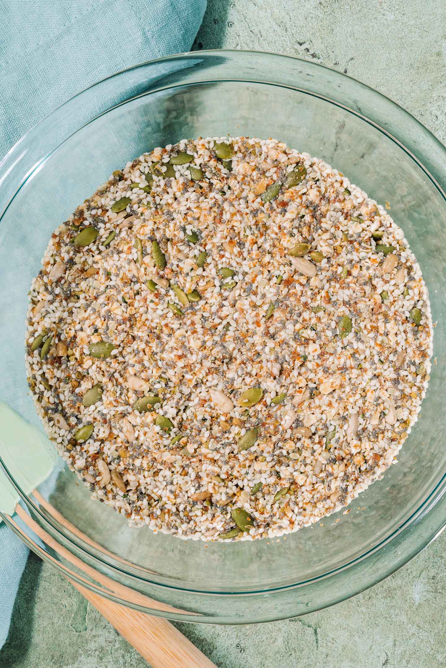 Top down view of a mixture of seeds in a bowl absorbing water to create a dough.