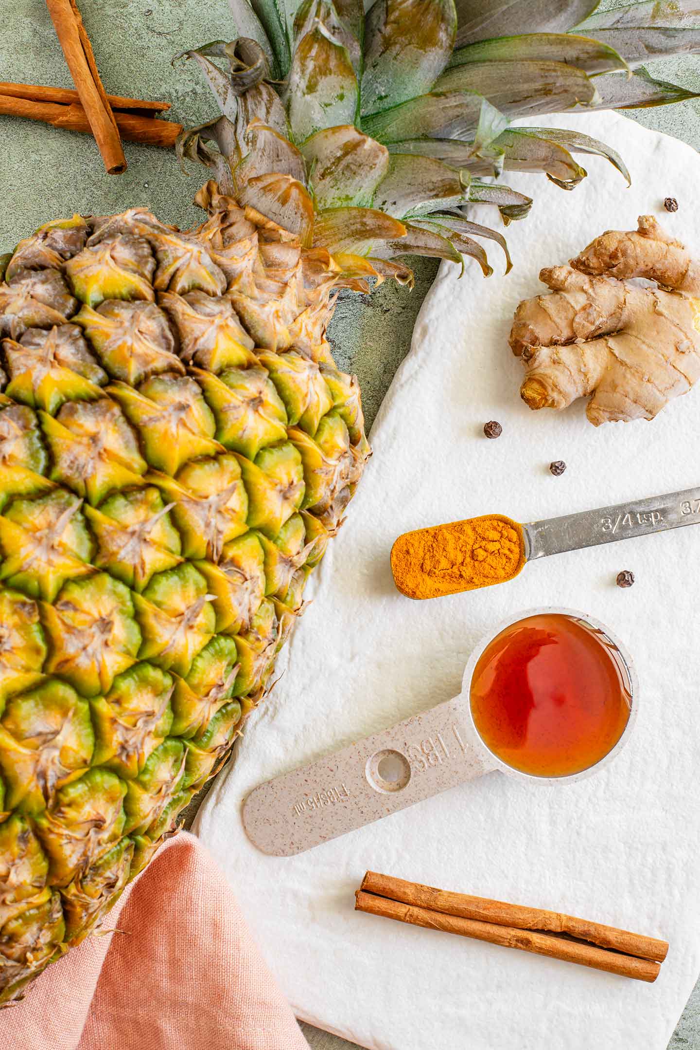 Top down view of a pineapple resting next to a tray of spices.