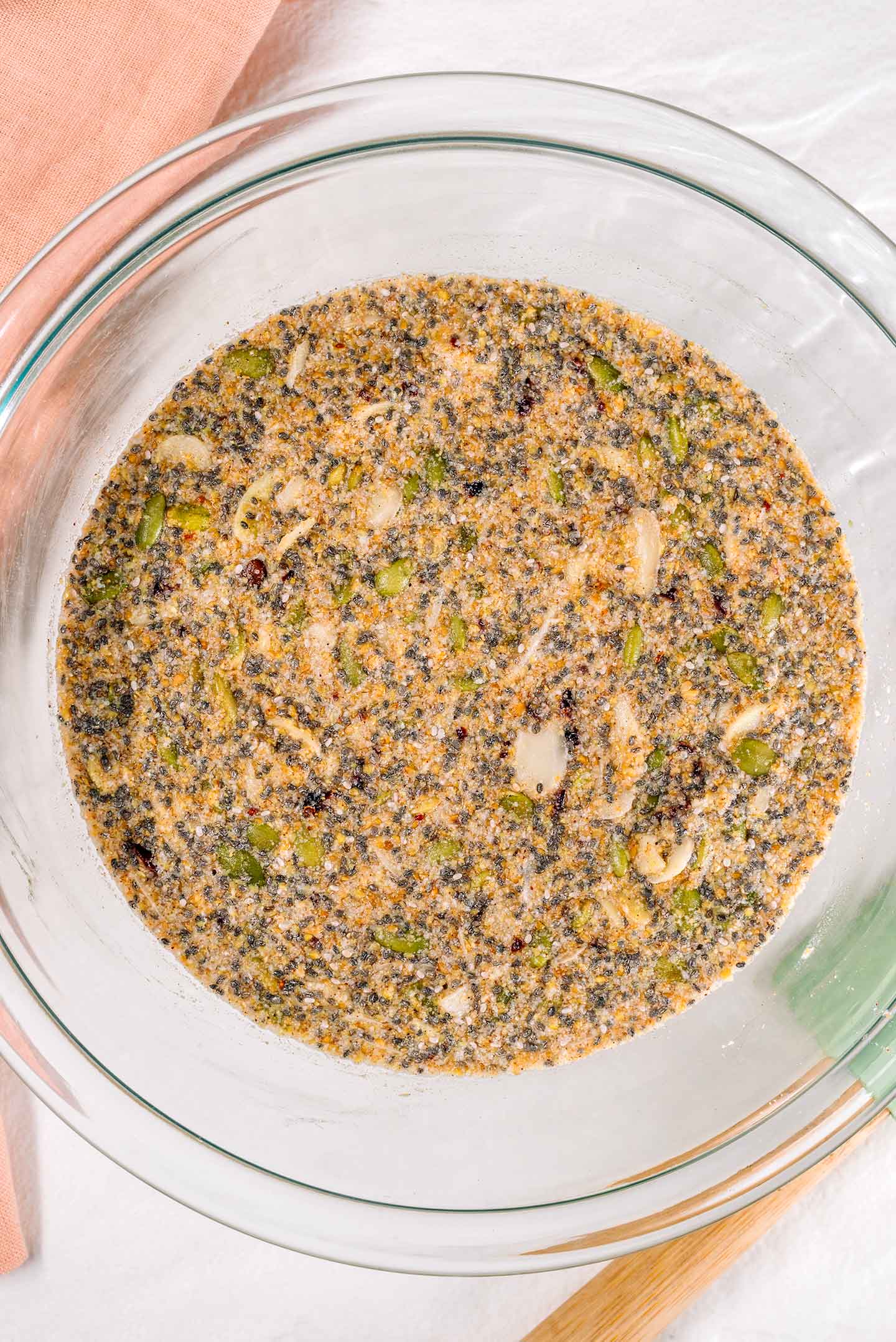 Top down view of the mixture soaking in a bowl. The seeds and almond flour have absorbed all the water.