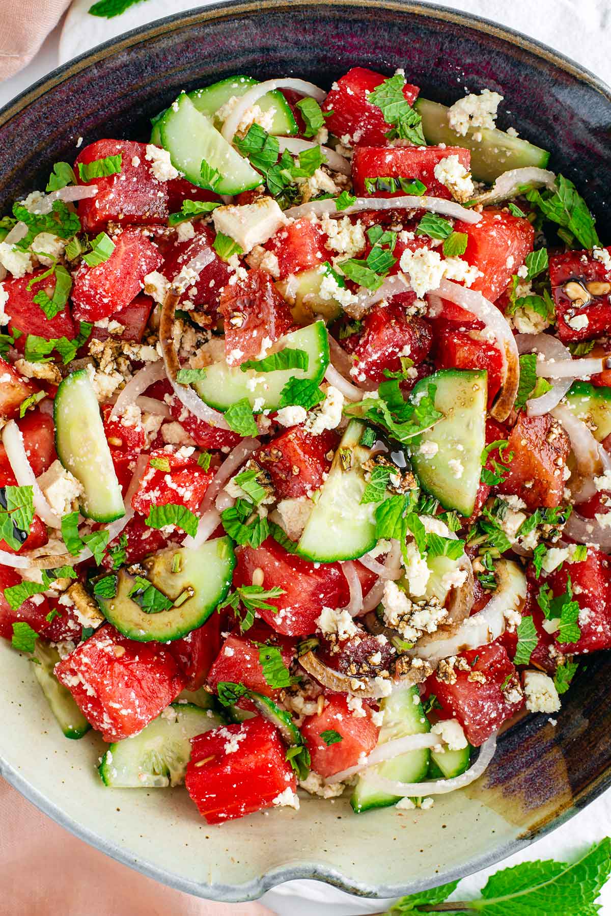 Top down view of a larger serving bowl of watermelon salad with tofu feta cheese. The salad is fresh, colourful, and perfect for summer.