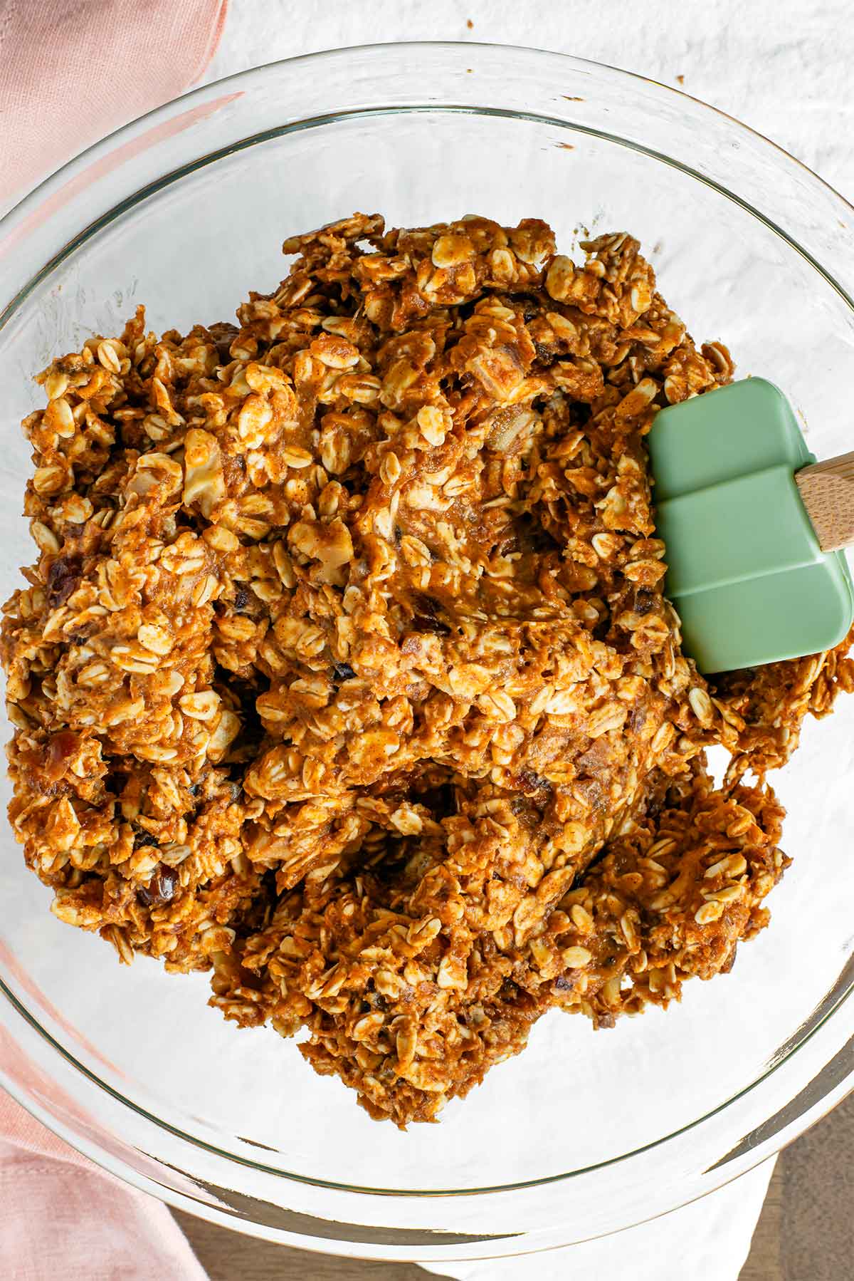 Top down view of the batter for healthy pumpkin cookies mixed in a bowl. The batter is more wet than a traditional cookie dough but firm enough to scoop.