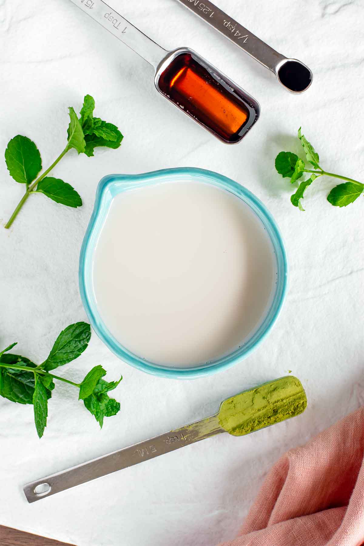 Top down view of ingredients for a mint matcha latte.